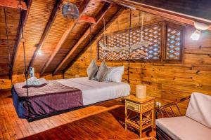 ein Schlafzimmer mit einem Bett in einem Holzzimmer in der Unterkunft Guapil #10 in Dominical