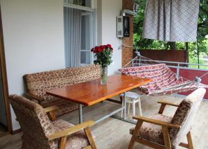 una mesa y sillas en un porche con un jarrón de flores en Green Corner en Lagodekhi