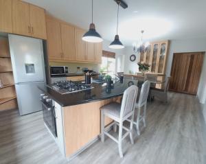 a kitchen with a island with a stove and a refrigerator at Silverdunes - GardenView in Bettyʼs Bay