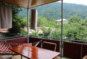 uma mesa e cadeiras numa varanda com vista em Green Corner em Lagodekhi