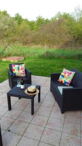 2 Sofas und ein Couchtisch auf einer Terrasse in der Unterkunft Gite Sologne in Marcilly-en-Gault