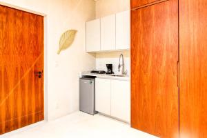 uma cozinha com armários brancos e uma porta de madeira em Amelia 104 Studio em Tulum