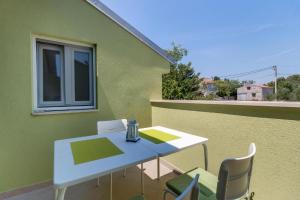 a white table and chairs on a balcony at Meer in Nerezine