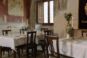 een eetkamer met witte tafels en stoelen met bloemen bij Castel Di Luco in Acquasanta Terme