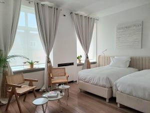 ein Schlafzimmer mit einem Bett und Stühlen sowie einem Fenster in der Unterkunft Les Lofts d'Artistes in Brüssel