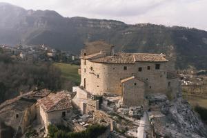 un ancien bâtiment au sommet d'une montagne dans l'établissement Castel Di Luco, à Acquasanta Terme