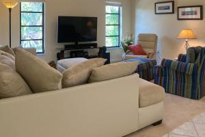 uma sala de estar com um sofá branco e uma televisão em Myakka Magic em Port Charlotte