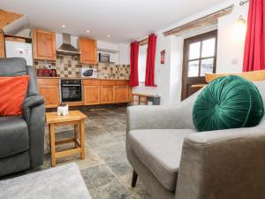 a living room with two couches and a kitchen at Keepers Cottage in Liskeard