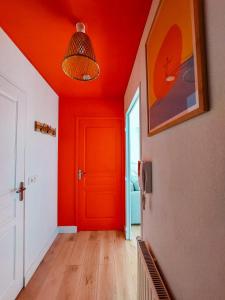 um corredor com um tecto vermelho e uma porta vermelha em Appart chaleureux proche bassin em Arès