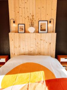 1 dormitorio con 1 cama con pared de madera en Appart chaleureux proche bassin en Arès