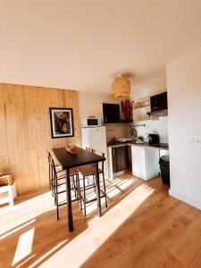 uma cozinha com mesa e cadeiras num quarto em Appart chaleureux proche bassin em Arès