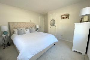 1 dormitorio blanco con 1 cama grande con sábanas y almohadas blancas en Patrician Shores Beach Abode, en Meredith