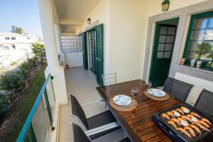 a wooden table on a balcony with a grill at Holiday Albufeira in Albufeira