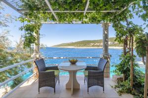 a patio with a table and chairs and the ocean at Apartments Ranko in Zavalatica