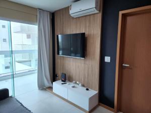 a bathroom with a sink and a tv on a wall at Apartamento com Garagem Cabo Frio in Cabo Frio