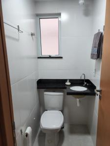 a white bathroom with a toilet and a sink at Apartamento com Garagem Cabo Frio in Cabo Frio +22 photos