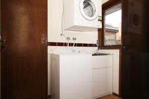 cocina con fregadero blanco y microondas en Rent Melbourne, en Melbourne 30 fotos más