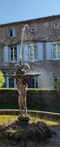 a water fountain with a statue of a person at Maison Riquet in Castelnaudary