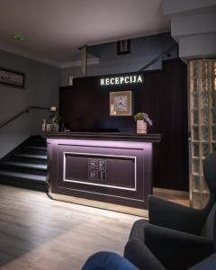 a lobby with a fireplace and a clock on the wall at Hotel & Restaurant Se-Mi in Veliko Trgovišće