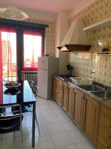 Guest House MICINI في Druento: مطبخ مع مغسلة وطاولة فيه