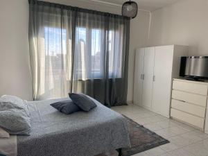 a bedroom with a bed and a tv and a window at Guest House MICINI in Druento