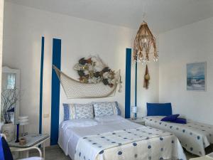 a bedroom with two beds and a hammock at B&B Mare E Natura in Cuile Ezi Mannu
