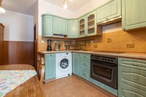 a kitchen with green cabinets and a washing machine at Gościniec Beskidzki in Bielsko-Biała