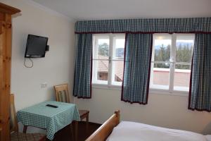 1 dormitorio con 1 cama, 1 mesa y 2 ventanas en Waldgasthof Passegger en Sankt Andrä im Lungau