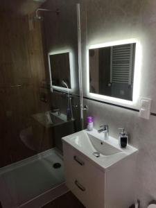 uma casa de banho com um lavatório, um espelho e uma banheira em 13 Starówka apartament Miodova em Toruń