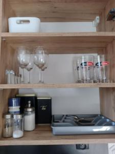 uma prateleira com copos de vinho e outros itens nela em 13 Starówka apartament Miodova em Toruń