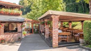 a brick building with a patio with tables and chairs at Hotel & Restaurant Se-Mi in Veliko Trgovišće