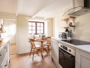 a kitchen with a table and a dining room at Swallow Cottage in Port Isaac