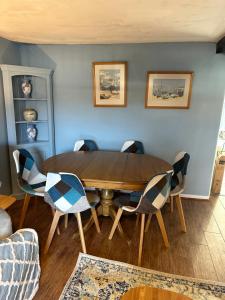 a dining room with a wooden table and chairs at 2 bedroomed fisherman’s cottage near quay in Blakeney