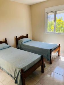two beds in a room with a window at Duplex Boulevard in Viedma