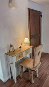 a desk with a chair and a table with a lamp at B&B ALLA PIAZZETTA DI TEGNA in Tegna