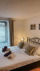 Schlafzimmer mit einem großen weißen Bett und einem Fenster in der Unterkunft B&B ALLA PIAZZETTA DI TEGNA in Tegna