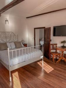 a bedroom with a bed and a table and a television at B&B ALLA PIAZZETTA DI TEGNA in Tegna