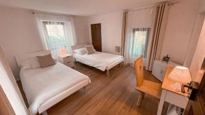 a bedroom with two beds and a table and a chair at B&B ALLA PIAZZETTA DI TEGNA in Tegna