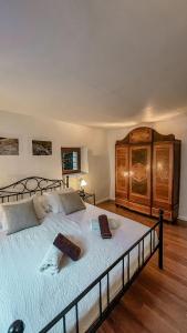 1 dormitorio con 1 cama grande y armario de madera en B&B ALLA PIAZZETTA DI TEGNA en Tegna