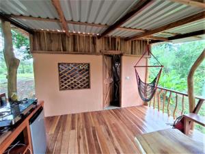 a room with a porch with a hammock on a deck at Terra NaturaMa - off grid living in the jungle in Punta Uva