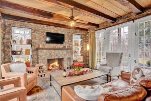 sala de estar con pared de piedra y chimenea en Chimney Hill Estate Inn, en Lambertville