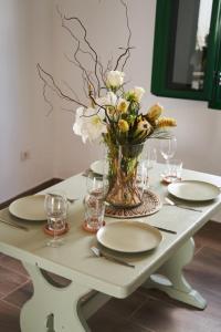 een tafel met borden en een vaas met bloemen erop bij CASA MINGO in Teguise