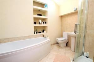 a bathroom with a tub and a toilet and a sink at Lovely 2 bedroom apartment in Kendal town centre in Kendal +9 photos