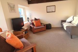a living room with a couch and a tv at Lovely 2 bedroom apartment in Kendal town centre in Kendal