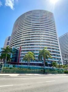 un gran edificio con palmeras delante en Condomínio Terraço do Atlântico, en Fortaleza