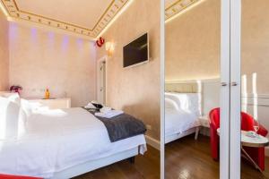 due immagini di una camera d'albergo con due letti di Piazza Venezia Luxury Suite a Roma