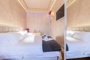 een slaapkamer met 2 bedden en witte lakens bij Piazza Venezia Luxury Suite in Rome