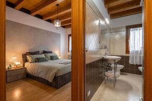 a bedroom with a bed and a bathroom with a sink at [Venezia-Suite Hemingway]a pochi passi Outlet in Noventa di Piave