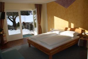 Un dormitorio con una cama grande y una ventana en Waldgasthof Passegger, en Sankt Andrä im Lungau