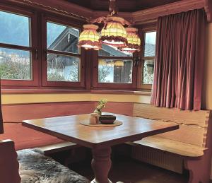 een eetkamer met een tafel en ramen bij Ferienhaus Weißachdamm am Tegernsee in Rottach-Egern